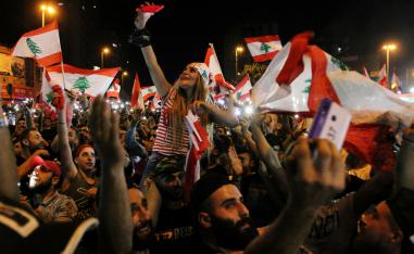 Demonstrators take pictures with their mobile phones during an anti-government protest in Tripoli