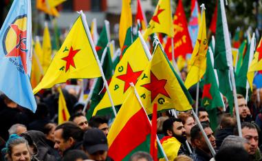 Pro-Kurdish demonstrators wave flags of the Kurdish YPG militia in Cologne, Germany