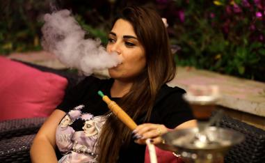 شابة تدخن الشيشة في أحد مقاهي لبنان