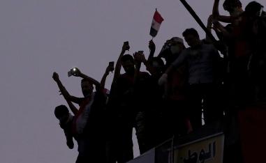 Iraqi anti-government protesters burn the Iranian flag during a demonstration in Baghdad