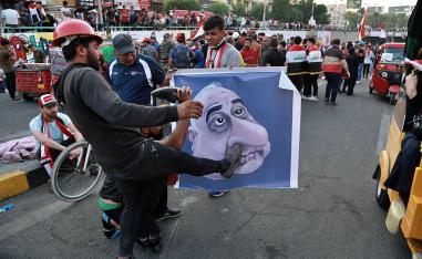 عراقيون يركلون تخطيطا لرئيس الوزراء العراقي عادل عبدالمهدي وسط بغداد