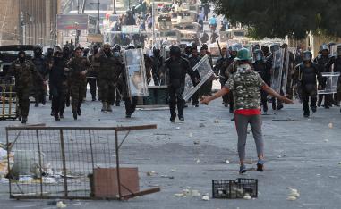 Iraqi anti-riot police try to prevent anti-government protesters from crossing the al- Shuhada (Martyrs) bridge