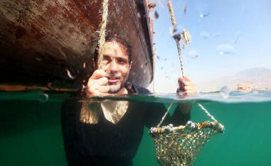 Emirati Abdullah al-Suwaidi demonstrates how his ancestors would pick up oysters off the seabed