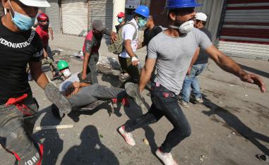 Iraqi demonstrators evacuate a wounded man on the Martyrs' Bridge in Baghdad