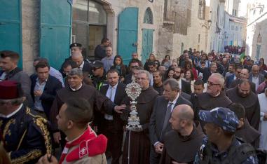 Christian clergymen carry a wooden relic believed to be from Jesus' manger in the Palestinian city of Bethlehem