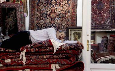 An Iranian carpet seller takes a nap in the old Bazaar in Tehran