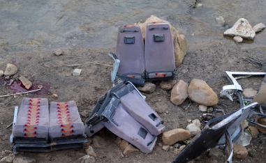 The remains of the bus in the ravine near a river bed
