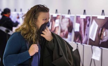 A woman reacts as she looks at a gruesome collection of images of dead bodies taken by a Syrian photographer, who has been identified by the code name "Caesar", at the United Nations Headquarters in New York.