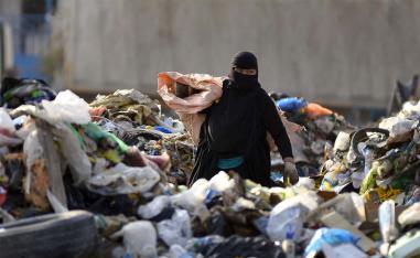 A woman collects recyclable items at a landfill to be sold for extra income in the Iraqi holy city of Najaf 