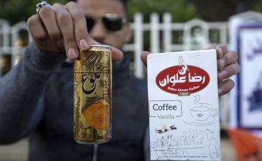 An Iraqi university student shows locally-made coffee and soft drink
