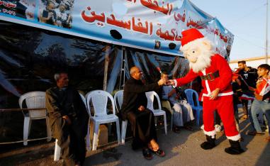 عراقي يرتدي بدلة بابا نويل يوزع الزهور على المحتجين في النجف