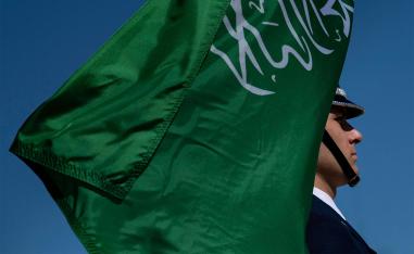 A color guard holds Saudi Arabia's flag 