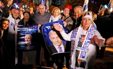 Israelis gather signs showing portraits of Israeli Prime Minister Benjamin Netanyahu