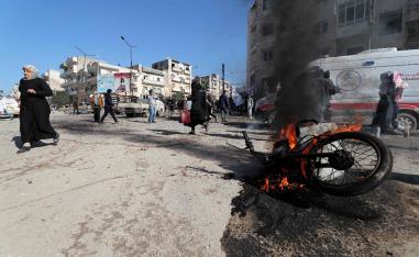 Panicked residents run following an air strike by pro-regime forces in the nothwestern Syrian city of Idlib