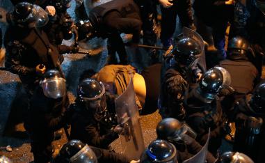 Riot police check a fainting anti-government protester during a demonstration to demand the release of detainees