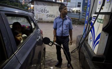 Indians get fuel filled in their car at a petrol pump in Gauhati, India