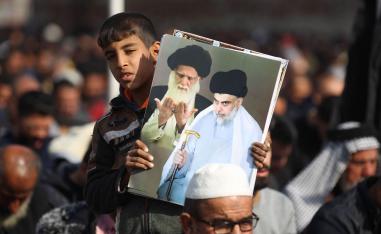طفل عراقي يرفع صورة مقتدى الصدر وأبيه الراحل محمد صادق الصدر