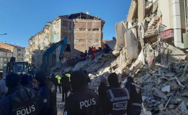 Turkish officials and police work at the scene of a collapsed building in Elazig, Turkey