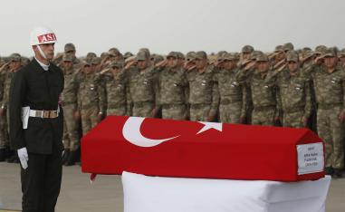 Turkish soldiers salute the Turkish flag-draped coffin of soldier Sefa Findik, killed in action in Syria last October