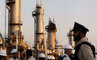 A security guard stands alert in front of Aramco's oil processing facility