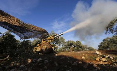 Turkish backed rebel fighters fire a howitzer toward Syrian government's forces positions near the village of Neirab in Idlib province