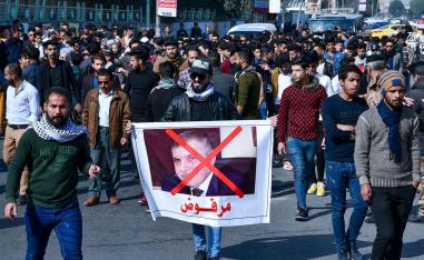 An Iraqi anti-government protester lifts a banner depicting the new Prime Minister-designate Mohammad Allawi with the inscription "rejected",