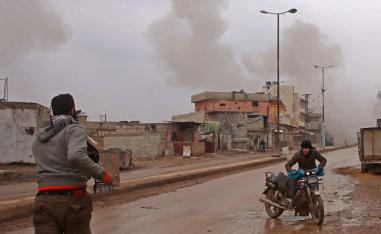 Syrian men flee the town of Atareb in the rebel-held western countryside of Syria's Aleppo province