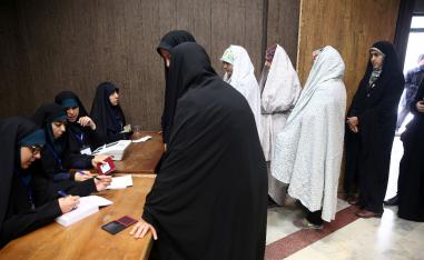 Women line up before they cast their vote during parliamentary elections at a polling station in Tehran
