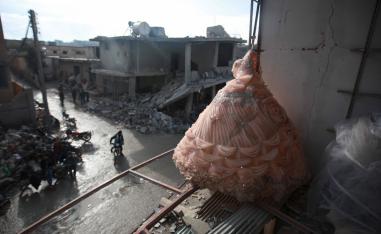 A wedding dress is seen in the destroyed window of a bridal shop in a damaged building in Balyun in Syria's Idlib province
