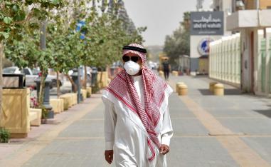 سعودي يضع كمامة للوقاية من فيروس كورونا يمشي في أحد شوارع الرياض