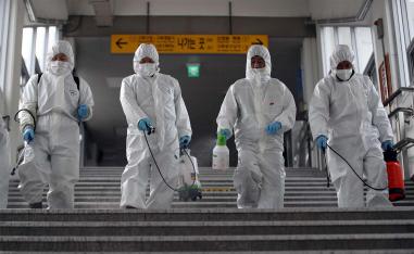 Workers wearing protective gear spray disinfectant to help prevent the spread of the COVID-19 coronavirus, at a subway station in Seoul 