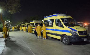 Egyptian health ministry emergency responders stand next to ambulances