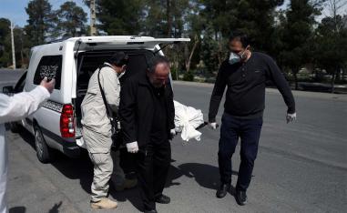 Iranian men carry the coffin of the journalist Abdollah Zavieh, who passed away due to coronavirus disease