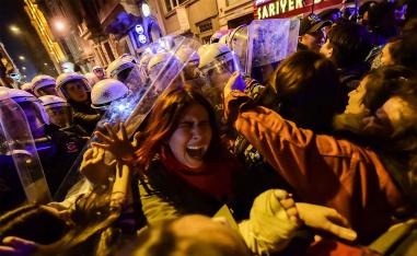 Turkish anti-riot police officers push back women during a rally marking International Women's Day on Istiklal avenue in Istanbul 