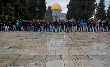 Palestinian Muslims pray in smaller numbers than usual during the weekly Friday noon prayer in Jerusalem