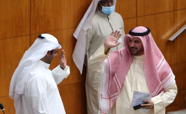 النائبان الكويتيان حمدان العازمي وراكان النصف يحييان بعضهما برفع أيديهما خلال جلسة برلمانية