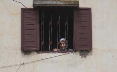 A woman looks out of her window during a health state of emergency and home confinement order in Rabat