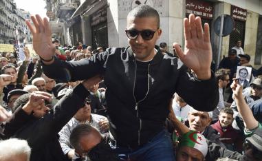 Algerian protesters carrying journalist Khaled Drareni on their shoulders