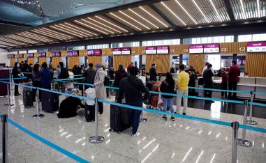 Passengers wearing protective face masks queue for a check-in, during the outbreak of the coronavirus disease (COVID-19), at Istanbul Airport