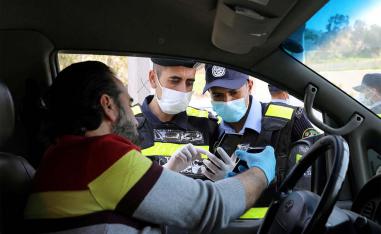 Jordanian policemen check the electronic pass of a driver in Amman