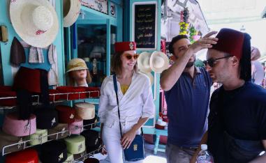 A tourist tries on a traditional fez at a bazaar in the Medina of Tunis