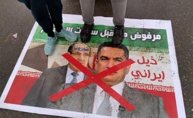 متظاهرون عراقيون يدوسون على صورة تجمع عدنان الزرفي ونوري المالكي