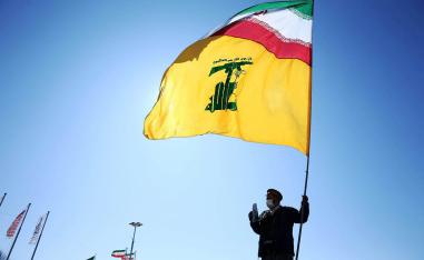 إيراني يرفع علما مشتركا لإيران وحزب الله
