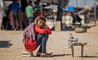 A displaced Syrian girl sits at the Washukanni camp