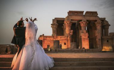 زوجان مصريان يحتفلان بزفافهما أمام معبد في أسوان