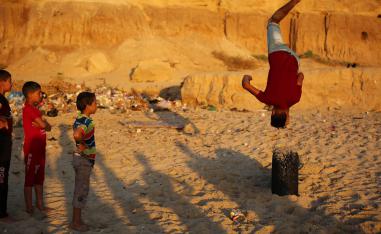 أطفال فلسطينيون يلعبون على ساحل البحر في دير البلح - غزة