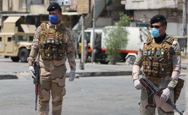 Iraqi security forces stand guard at a checkpoint in Baghdad