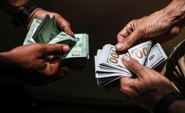 لبنانيان يصرفان دولارات مقابل الليرة