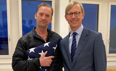 Michael White, a freed US Navy veteran detained in Iran since 2018, poses with US Special Envoy Brian Hook