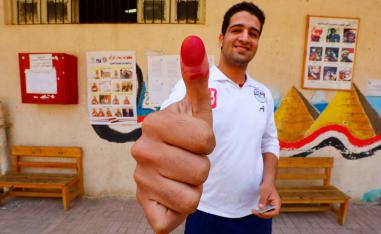 مصري يشير إلى مشاركته بالانتخابات